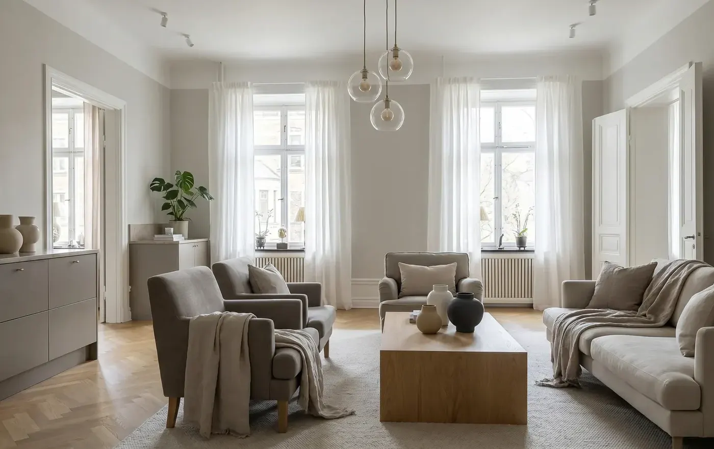 Séjour d’un appartement ancien rénové : parquet, hautes fenêtres et canapés clairs