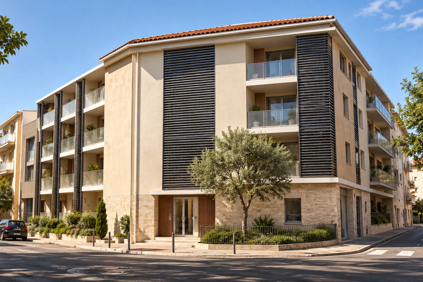 Résidence de logements à l’angle de deux rues : façades claires, balcons et brise-soleil sombres