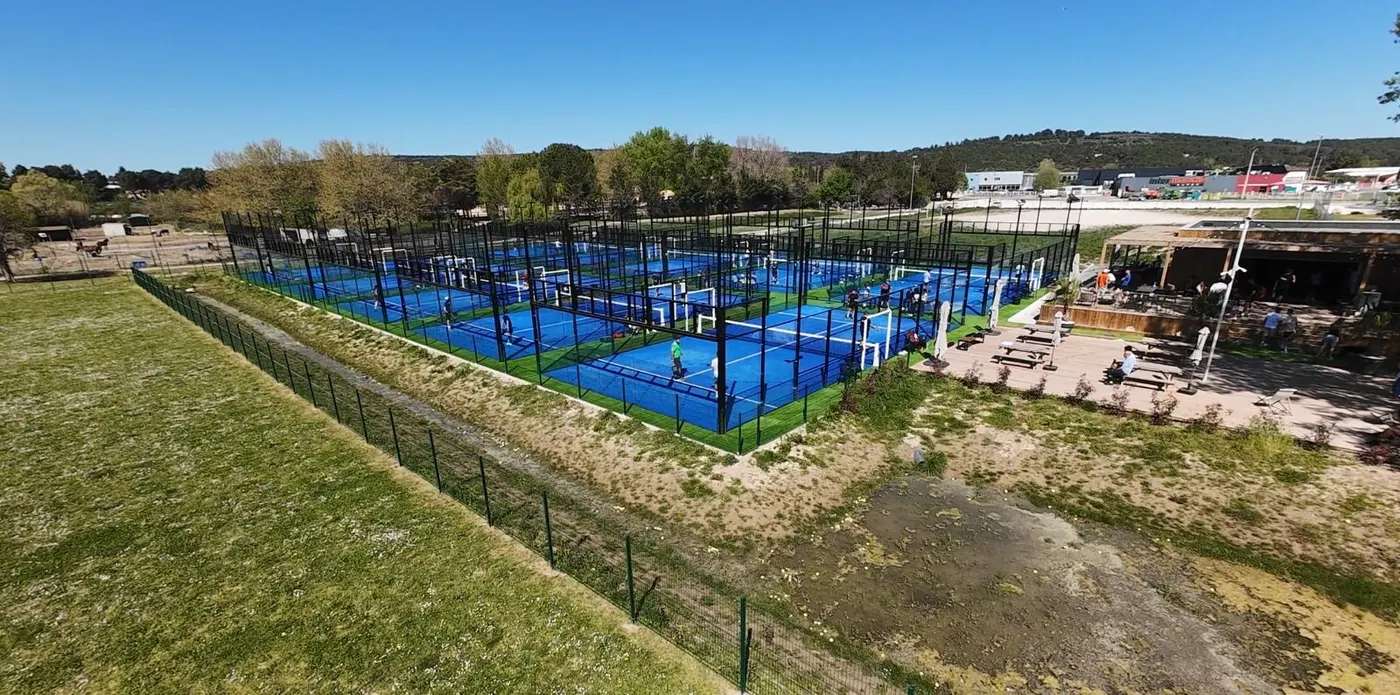 Parc Praden&nbsp;– Création du centre&nbsp;: vue aérienne des terrains bleus, alignés en long à côté du club-house